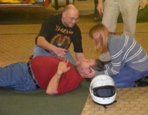 First aid practise - helmet off A practise first aid session, with a volonteer being taught to the basics
