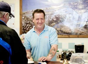 Danny, a chap with a tattoo on his arm, serving coffee in a cafe