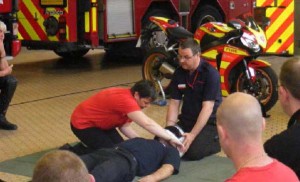 A practice first aid session, with another volonteer being taught to the basics by one of the biker down team.