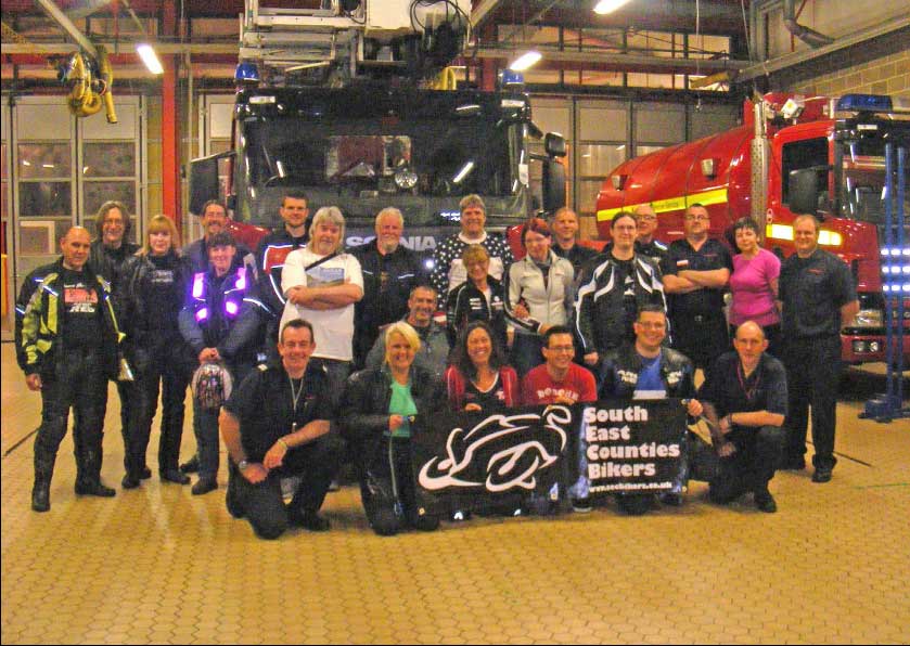 The South East Counties Bikers with the Biker Down team The South East Counties Bikers with the Biker Down team in a group portrait in the fire station, with the appliances behind them.