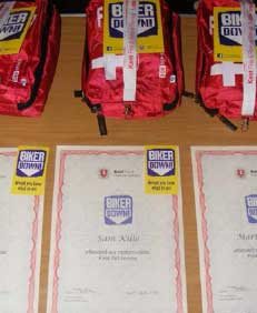 Biker down certificates with first aid kits A close up shot of some of the Biker down certificates with first aid kits in the background.