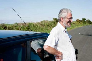 Steve, a local Manxman, leaning on his car on the side of the road