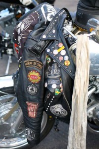 Picture of a leather bike jacket covered in rocker badges hanging on the bars of a BSA Rocket Gold Star