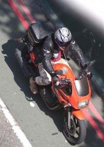 View from above of a despatch rider riding his bike wearing combats
