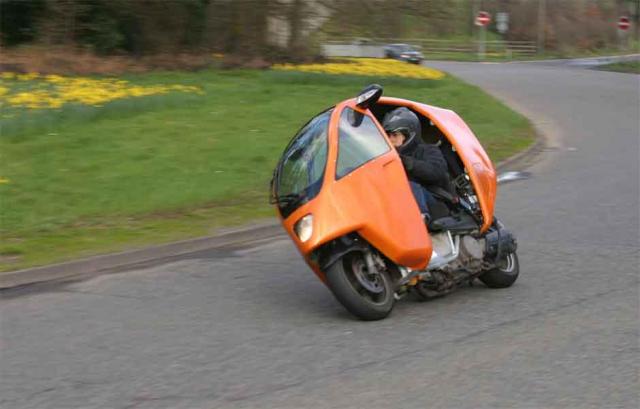 Paul cornering the Pegram Genesis, wearing a helmet and jeans on a race circuit right hander.