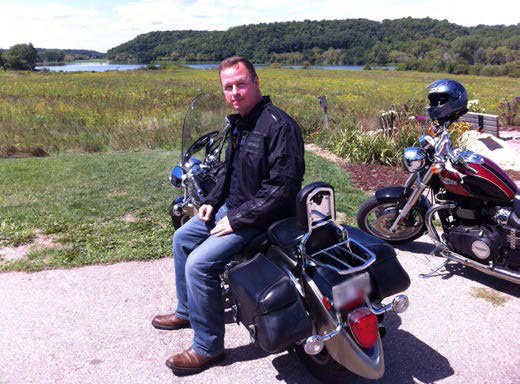 Dave sitting on his Harley in the sun